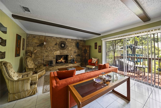 tiled living room with beam ceiling, a fireplace, and a textured ceiling