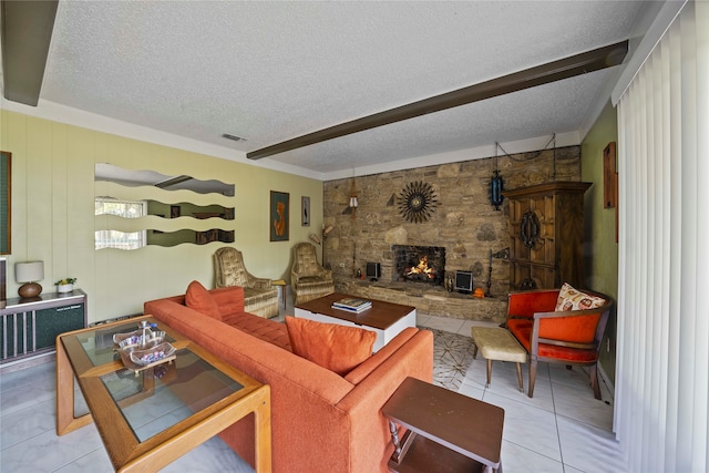 tiled living room with a textured ceiling and a stone fireplace