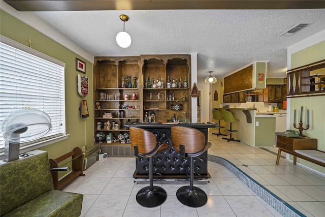 bar featuring light tile patterned floors and a textured ceiling