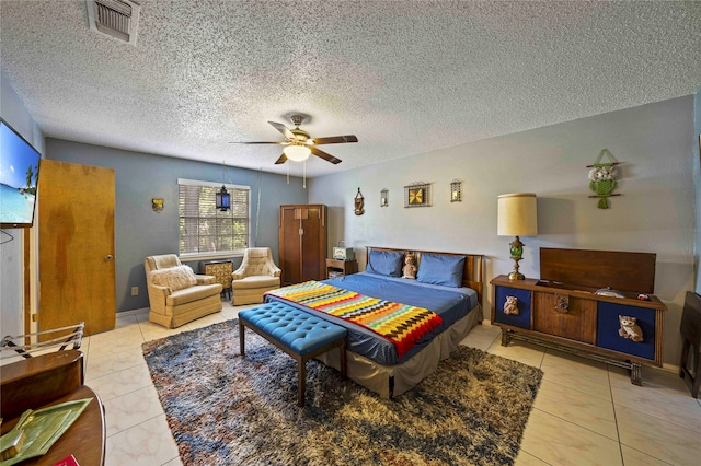 bedroom featuring light tile patterned floors, a textured ceiling, and ceiling fan