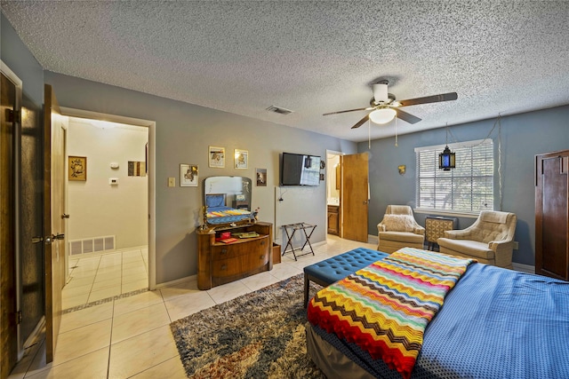 tiled bedroom with ceiling fan and a textured ceiling