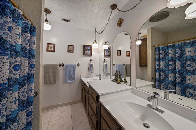 bathroom featuring vanity, a textured ceiling, and walk in shower