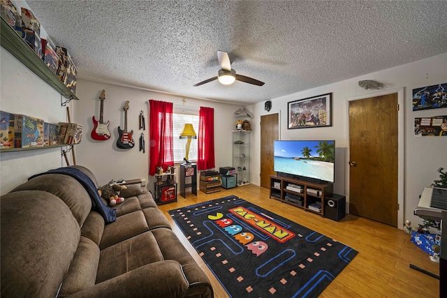 living room featuring ceiling fan, wood-type flooring, and a textured ceiling