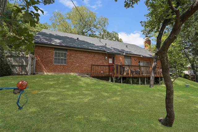 rear view of property featuring a deck and a lawn