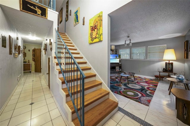 stairway featuring tile patterned flooring and a textured ceiling