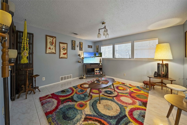 interior space featuring light tile patterned floors and a textured ceiling