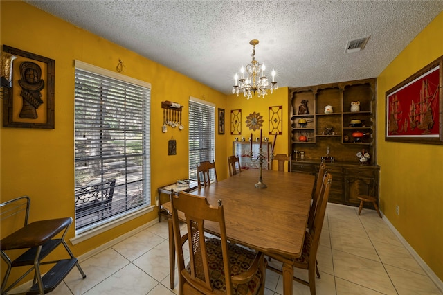 dining room featuring light tile patterned floors, a chandelier, and a textured ceiling