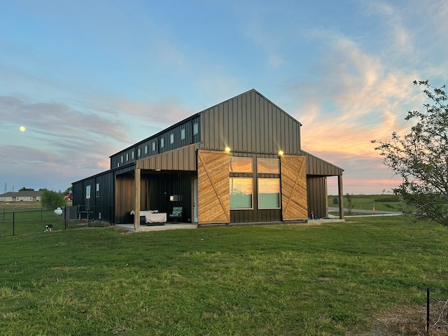 outdoor structure at dusk featuring a lawn