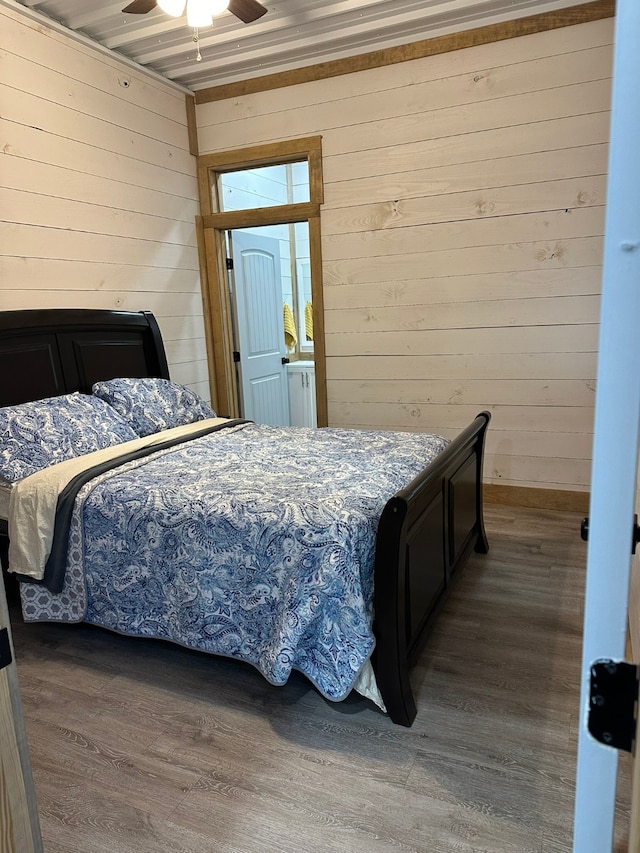 bedroom featuring wood-type flooring, wood walls, and ceiling fan