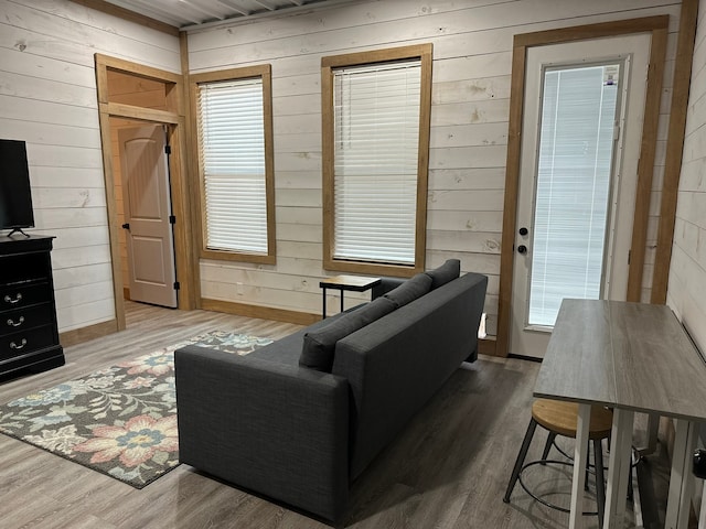 living room with hardwood / wood-style floors and wood walls