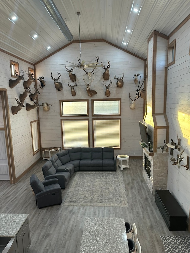 living room with vaulted ceiling, wood-type flooring, wooden ceiling, and a fireplace