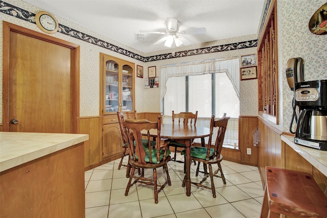 dining room featuring a textured ceiling, light tile patterned floors, and ceiling fan