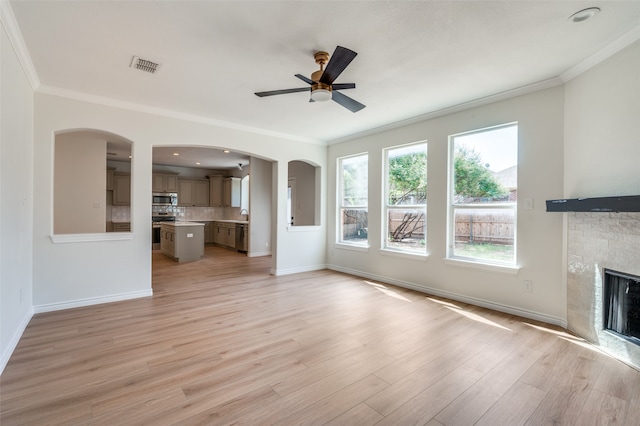 unfurnished living room featuring ceiling fan, ornamental molding, and hardwood / wood-style flooring