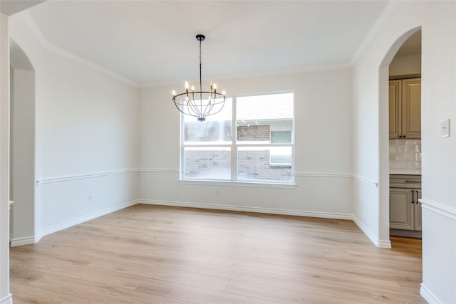 unfurnished dining area featuring ornamental molding, a chandelier, and light hardwood / wood-style floors