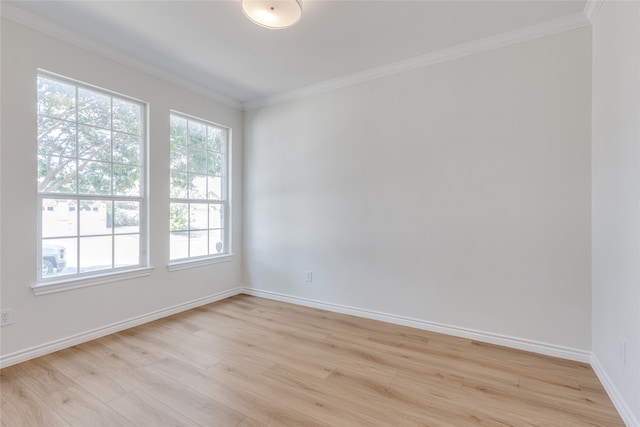 spare room featuring crown molding, a healthy amount of sunlight, and light wood-type flooring