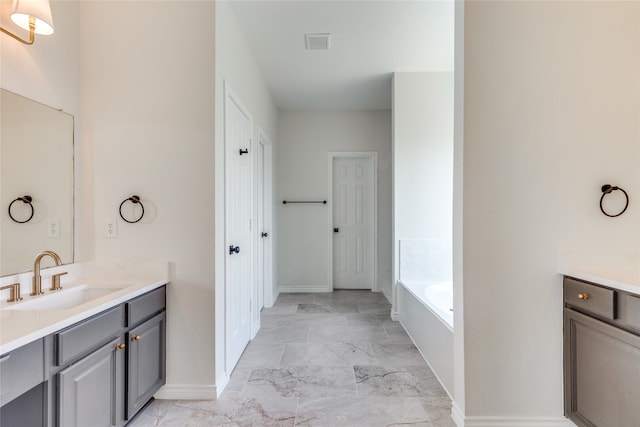 bathroom featuring tile patterned floors, a relaxing tiled tub, and vanity