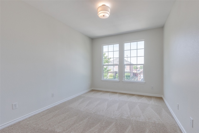 spare room featuring light colored carpet