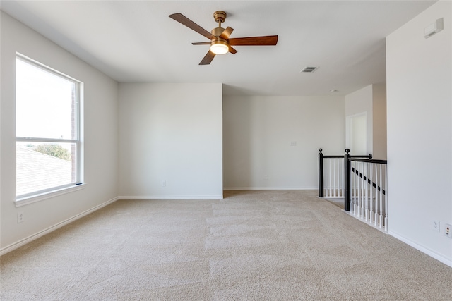 unfurnished room featuring light colored carpet and ceiling fan