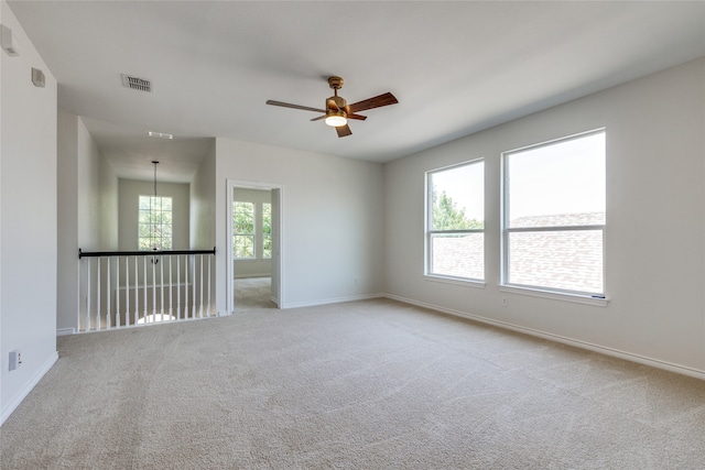 carpeted spare room featuring ceiling fan