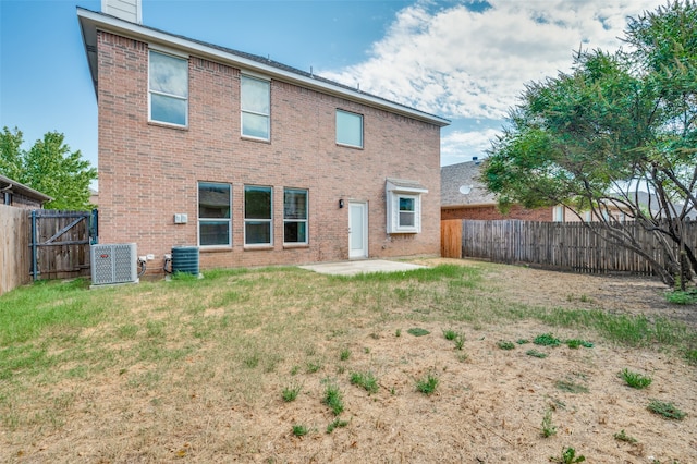 back of house featuring central AC unit, a patio area, and a lawn