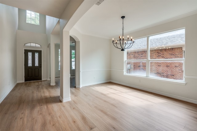 entryway featuring a healthy amount of sunlight, a notable chandelier, and light hardwood / wood-style flooring