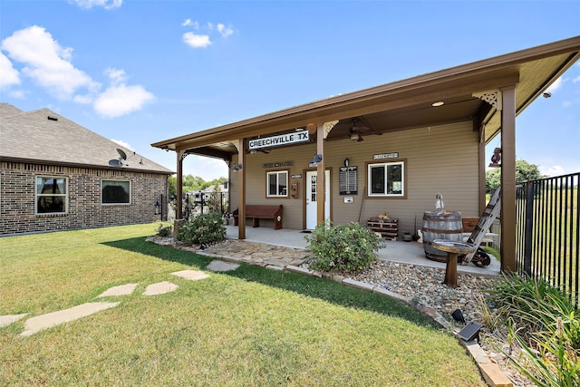 back of house featuring ceiling fan, a lawn, and a patio area