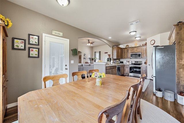 dining area featuring dark wood-type flooring, ceiling fan, and sink