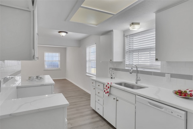 kitchen with white cabinets, sink, tasteful backsplash, dishwasher, and light wood-type flooring