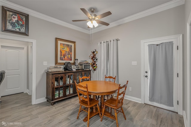 dining room featuring ornamental molding, light wood-type flooring, ceiling fan, and baseboards