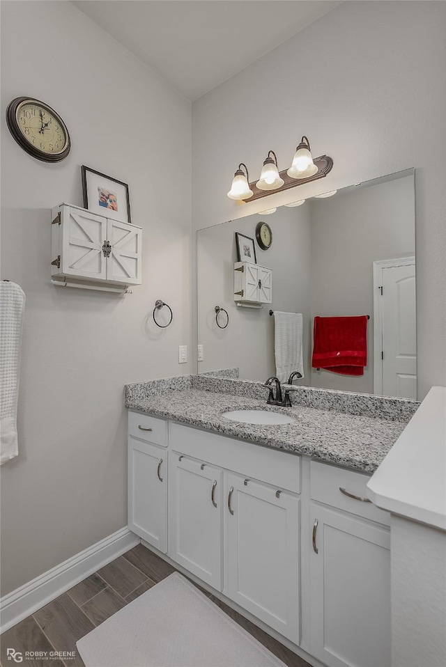 bathroom with baseboards, vanity, and wood tiled floor