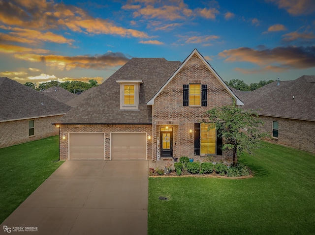 traditional-style house featuring a yard, brick siding, a shingled roof, and driveway