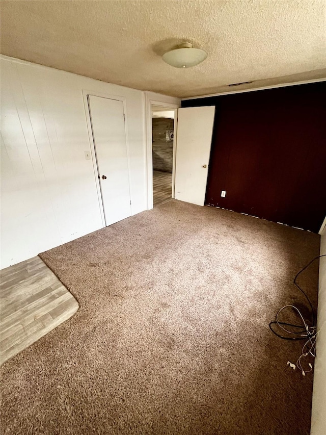 unfurnished bedroom with a textured ceiling and carpet flooring