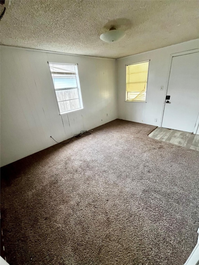 empty room with a textured ceiling and carpet