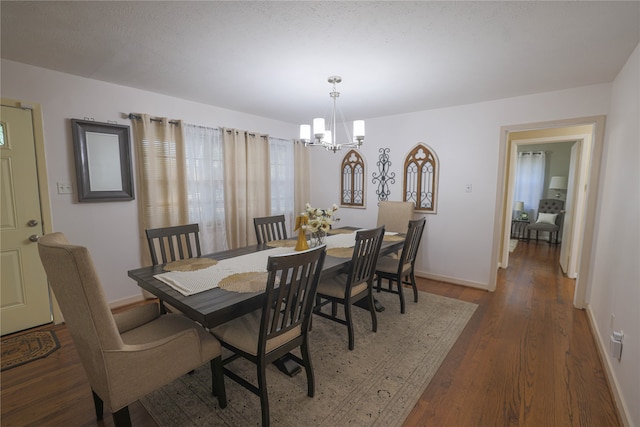 dining room featuring dark wood-type flooring and a notable chandelier