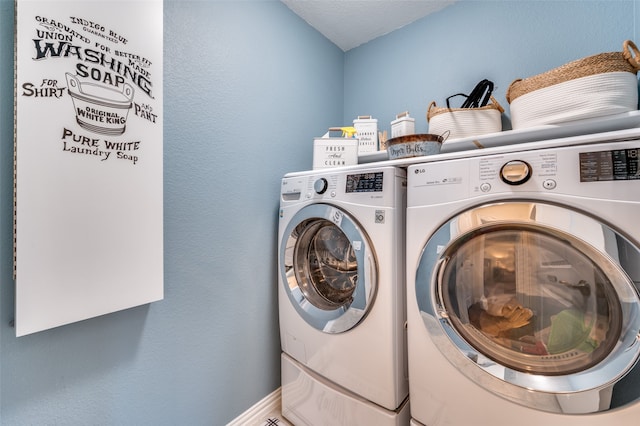 laundry area with independent washer and dryer and a textured ceiling