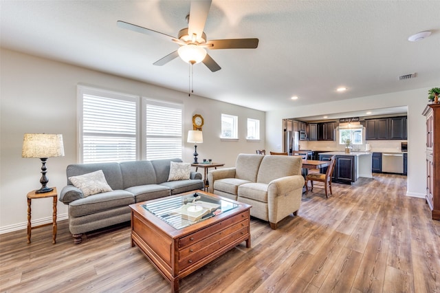 living room with hardwood / wood-style flooring and ceiling fan