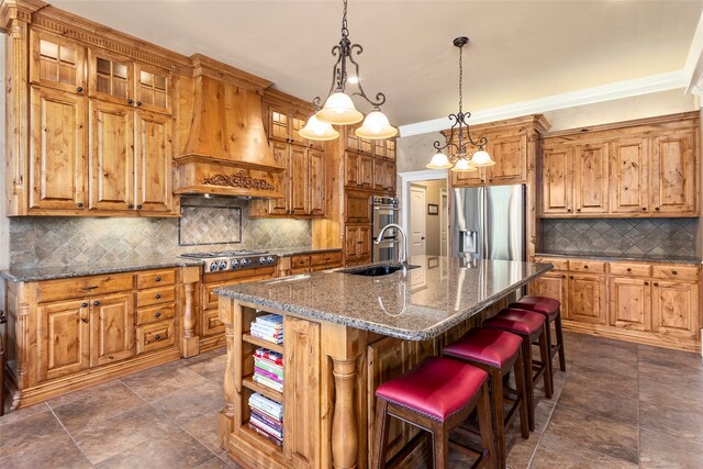 kitchen featuring a kitchen island with sink, custom exhaust hood, ornamental molding, sink, and appliances with stainless steel finishes