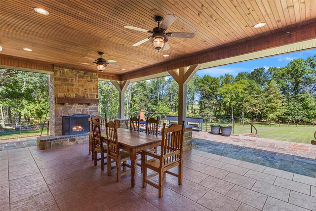 view of patio / terrace featuring an outdoor stone fireplace and ceiling fan