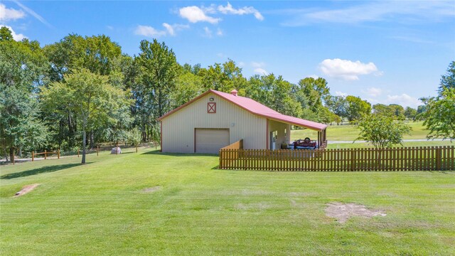 view of yard with a garage and an outbuilding