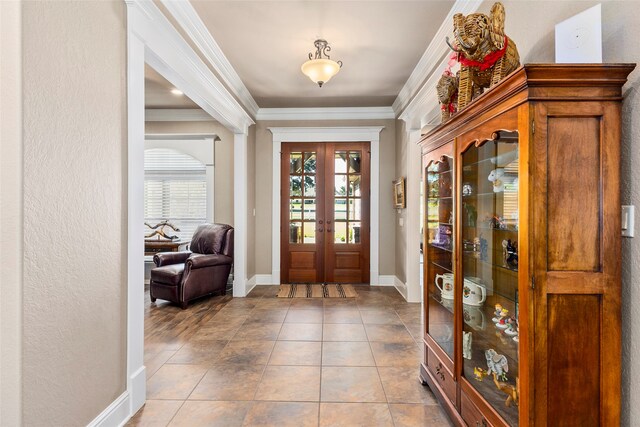 foyer with ornamental molding, light tile patterned floors, and french doors