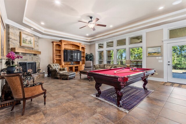 game room with a healthy amount of sunlight, ceiling fan, pool table, and a stone fireplace