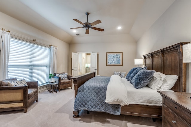 carpeted bedroom with ceiling fan, lofted ceiling, and ensuite bath