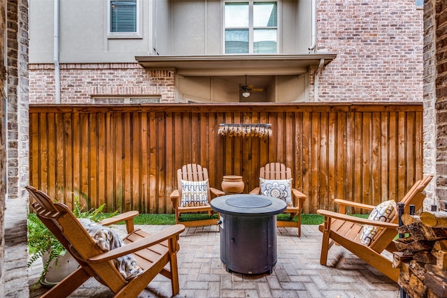 view of patio with ceiling fan and an outdoor fire pit