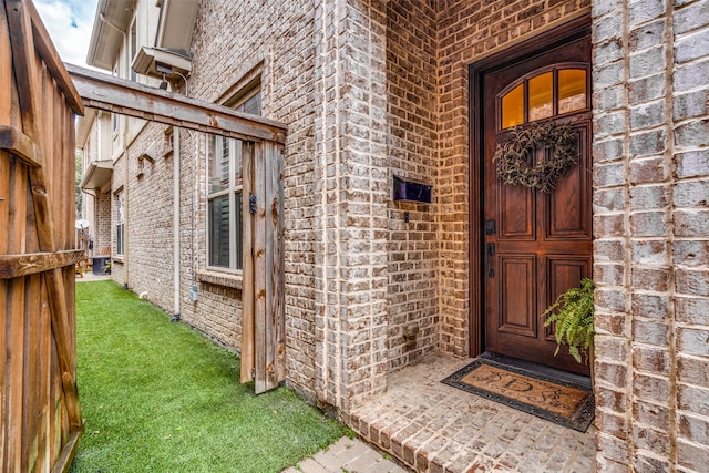 view of exterior entry featuring a yard