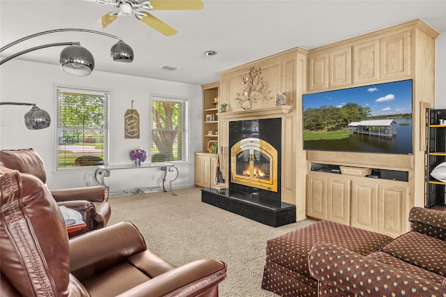 carpeted living room featuring ceiling fan and a fireplace