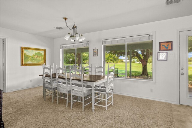 carpeted dining room with plenty of natural light and a notable chandelier