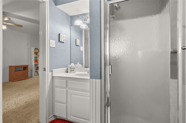 bathroom with ceiling fan, a shower with shower door, and vanity