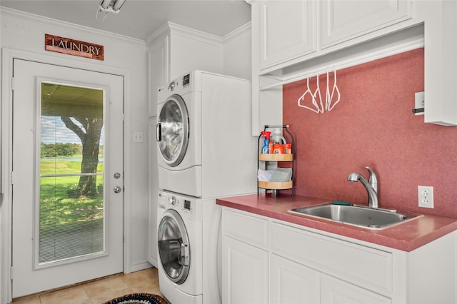 clothes washing area featuring cabinets, stacked washer and dryer, sink, ornamental molding, and light tile patterned flooring