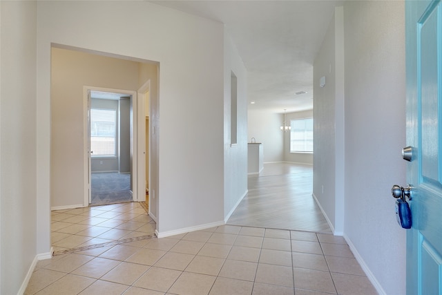 corridor with a wealth of natural light and light tile patterned flooring