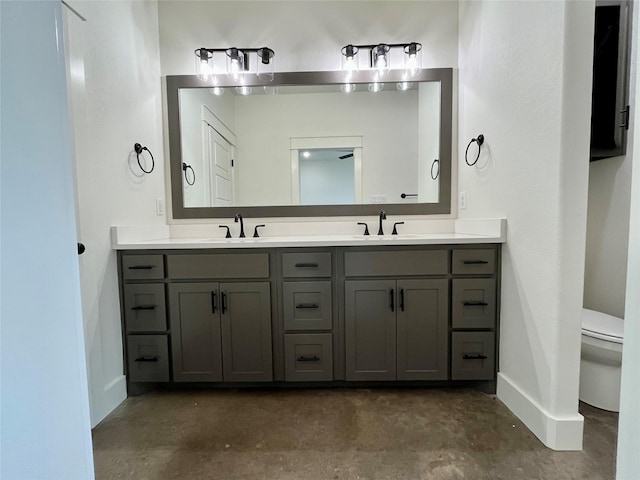 bathroom featuring vanity, concrete floors, and toilet